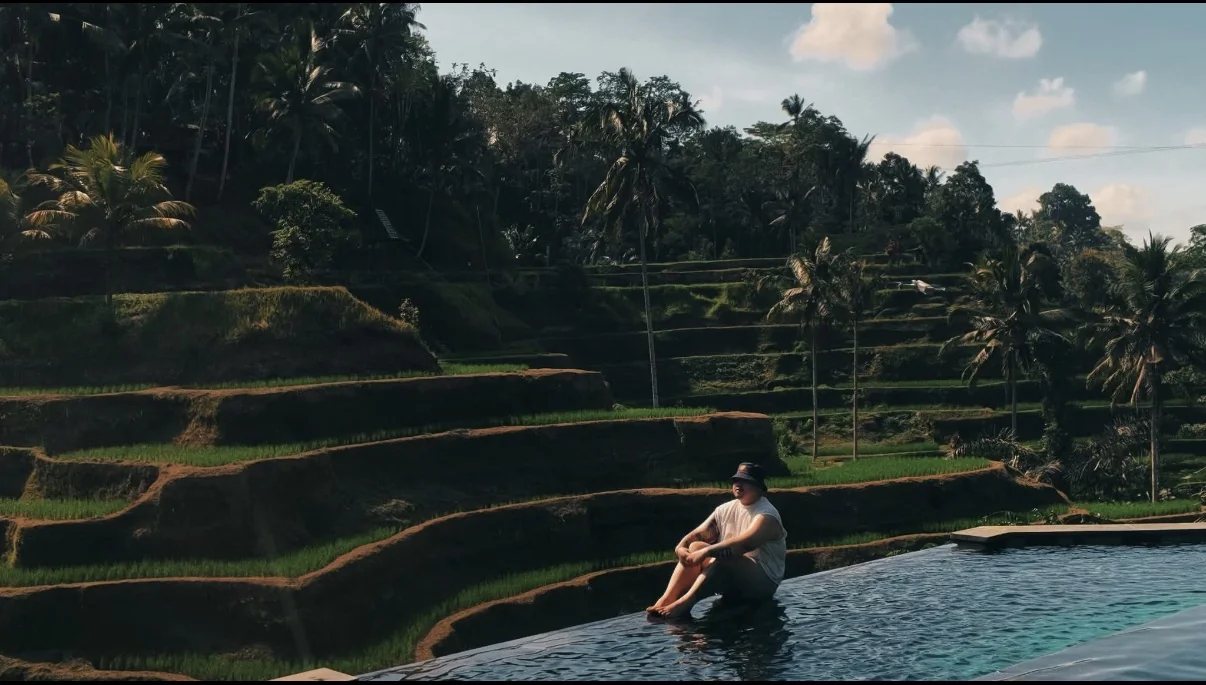 Ean beside an infinity pool overlooking green rice terraces