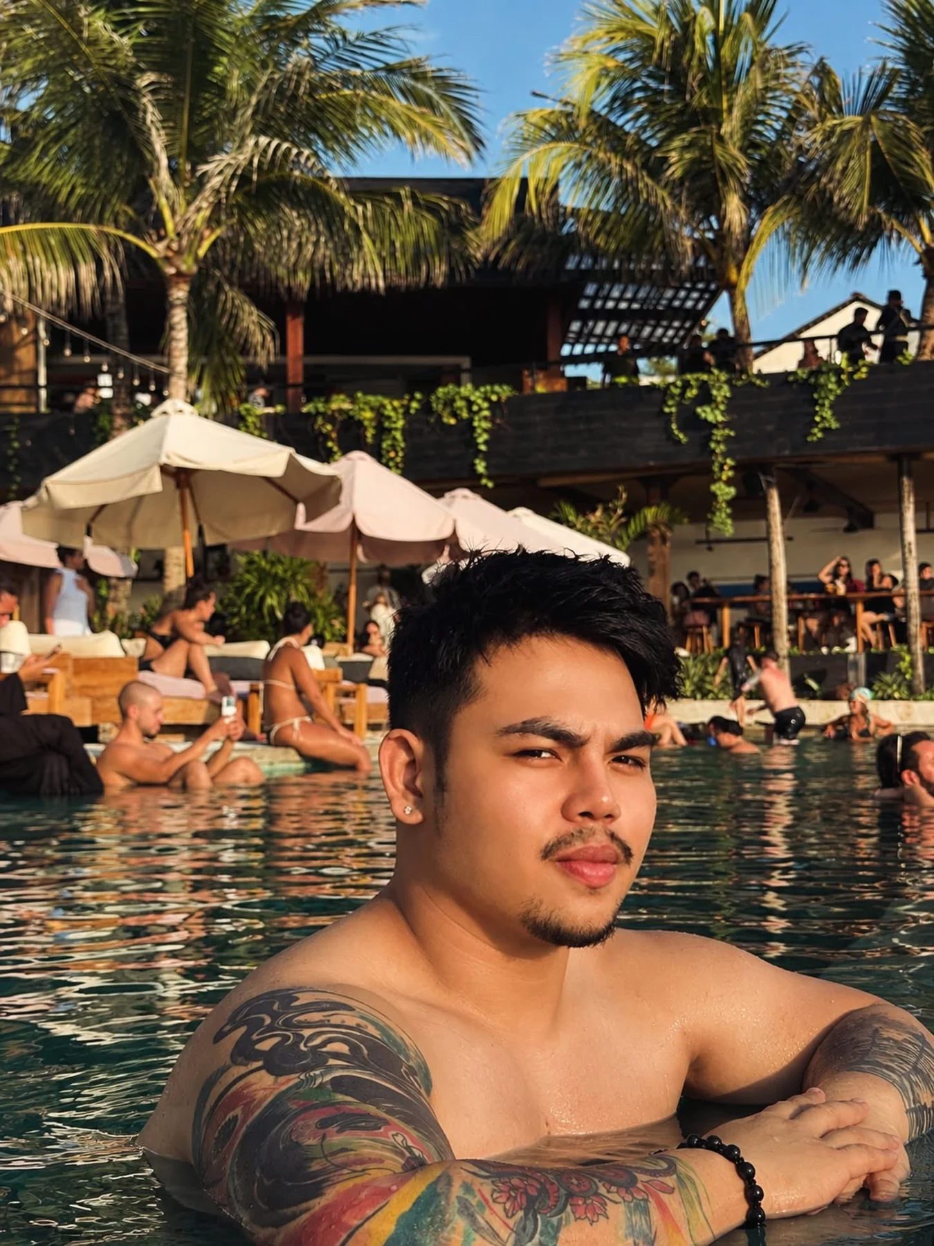 Ean at a palm-lined pool in the late afternoon